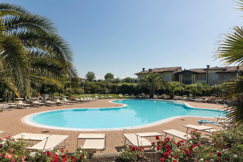 a swimming pool with lounge chairs and a resort at Charme Relax e Terrazza a Vista in Sirmione