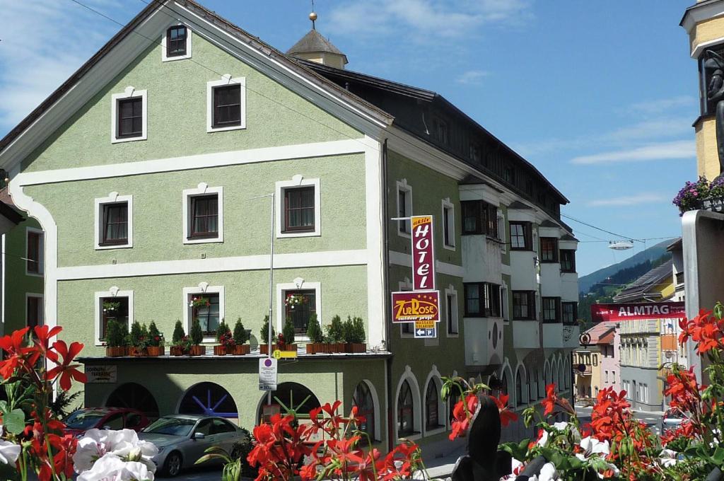 a green and white building with flowers in front of it at Aktiv Hotel Zur Rose am Brenner in Steinach am Brenner