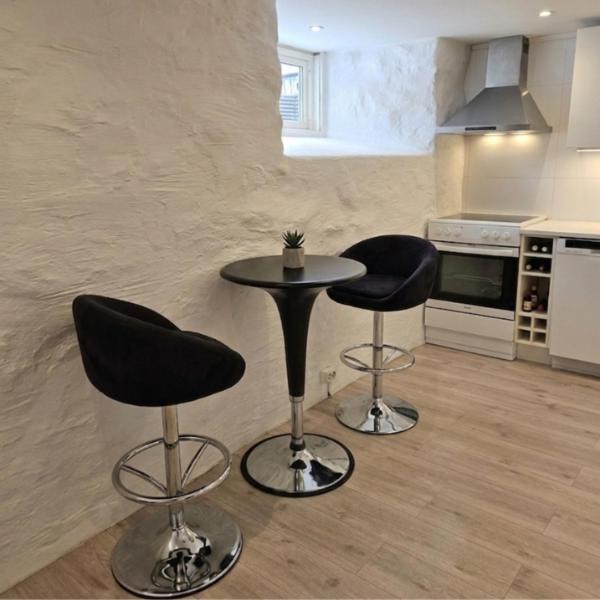 a kitchen with two bar stools and a table at Apartment in central Skien in Skien