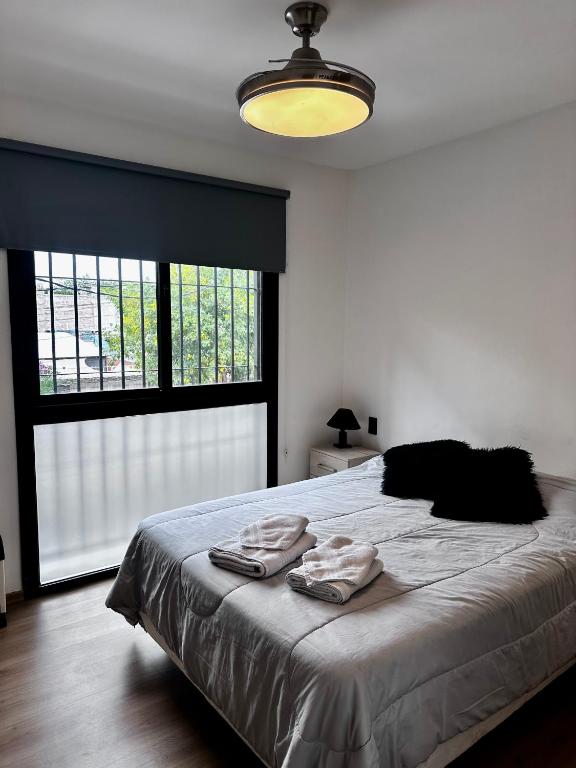 a bedroom with a bed with two towels on it at Terrazas de Godoy in Godoy Cruz