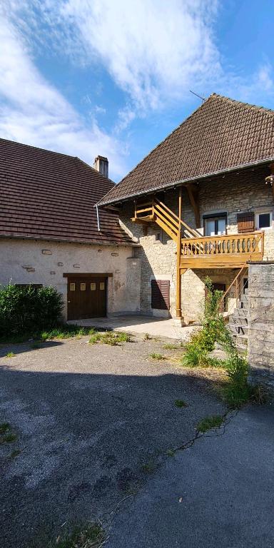 a house with a wooden stairway and a building at Le Domaine Des Petits Chat in Orchamps