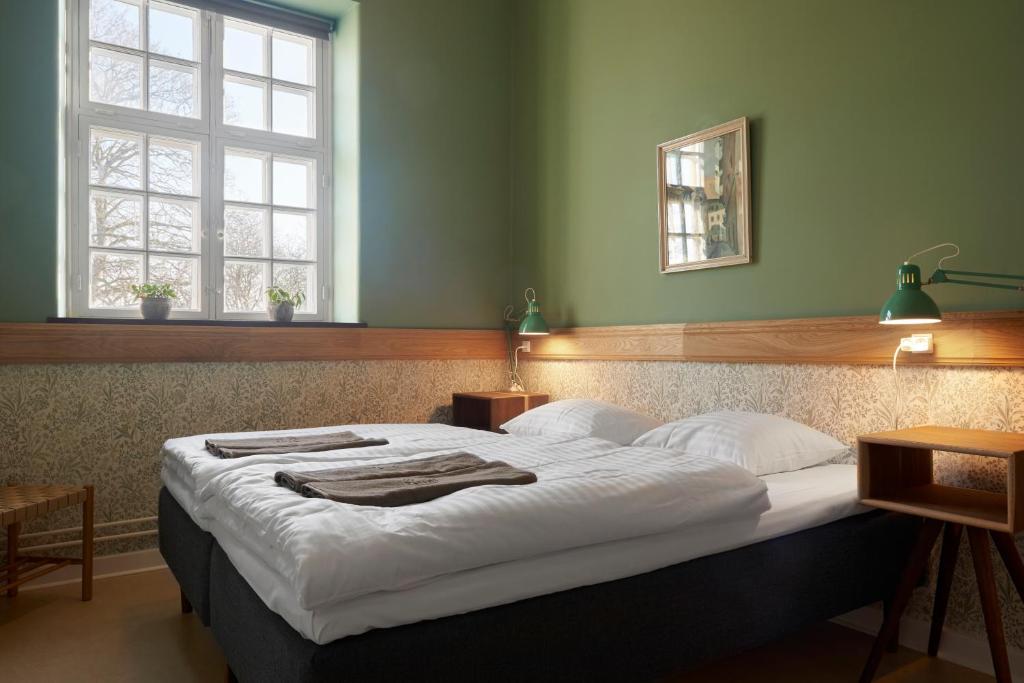 a bedroom with a large bed with white sheets at Anneberg Gæstehus in Nykøbing Sjælland