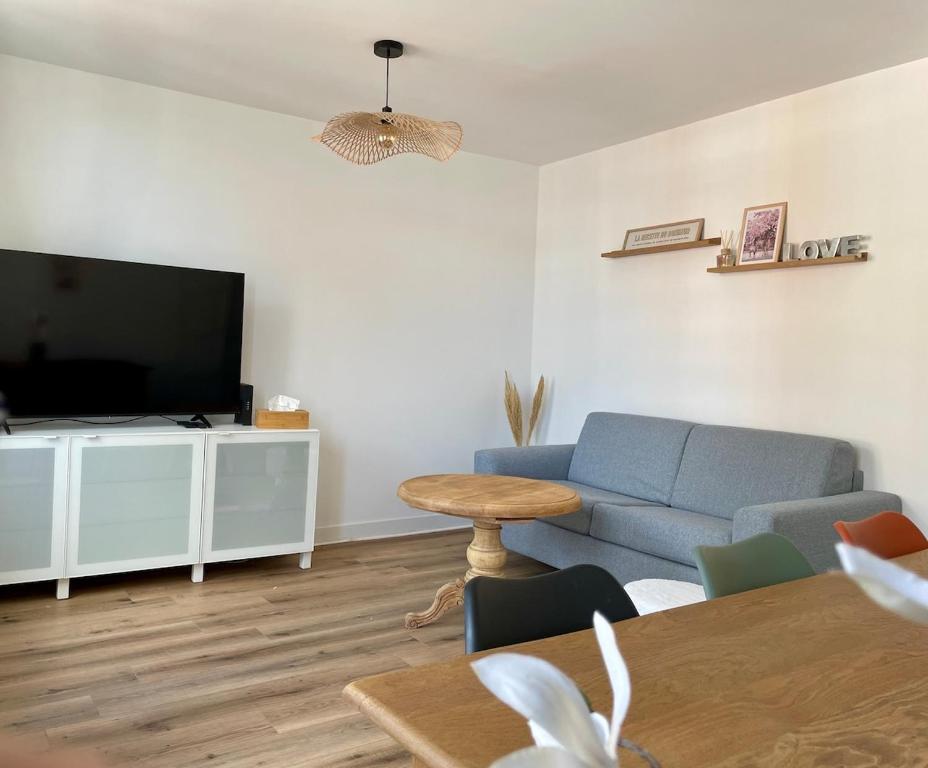a living room with a blue couch and a tv at Bohemian Rhapsody- Hyper centre Compiègne in Compiègne