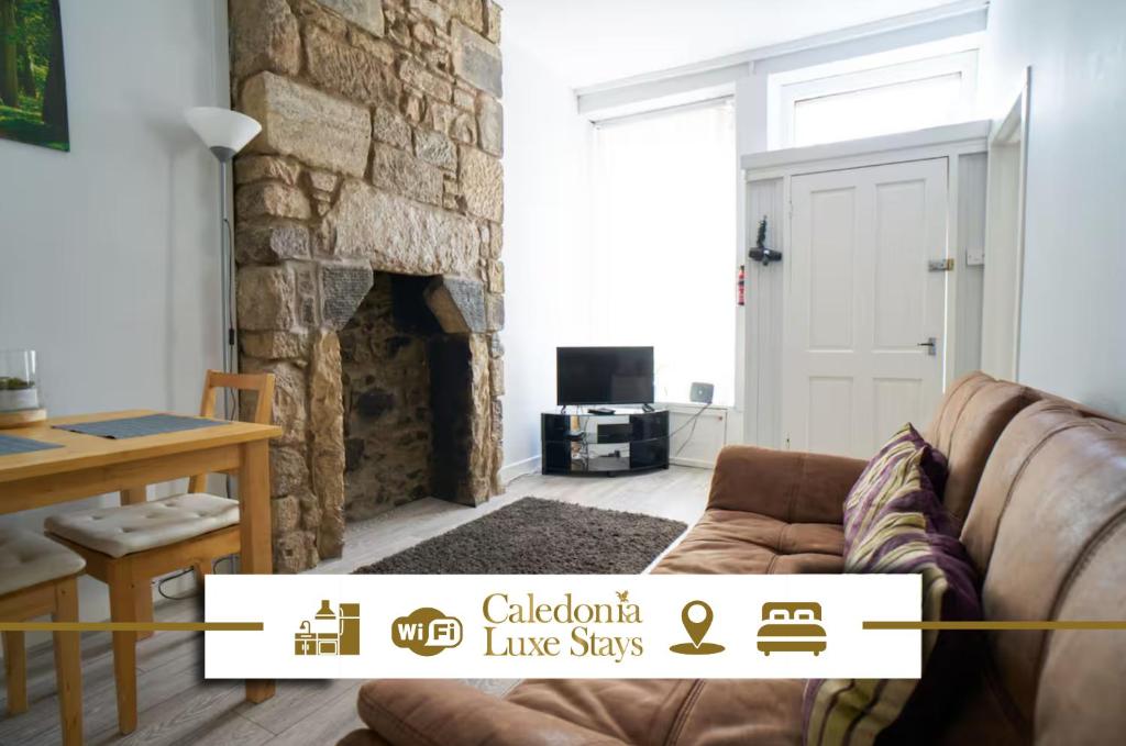 a living room with a couch and a stone fireplace at Douglas Gatehouse in Douglas
