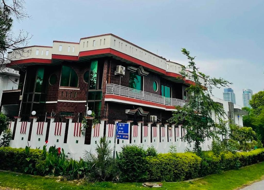 a building with a white fence in front of it at Executive Galaxy Guest House Islamabad in Islamabad
