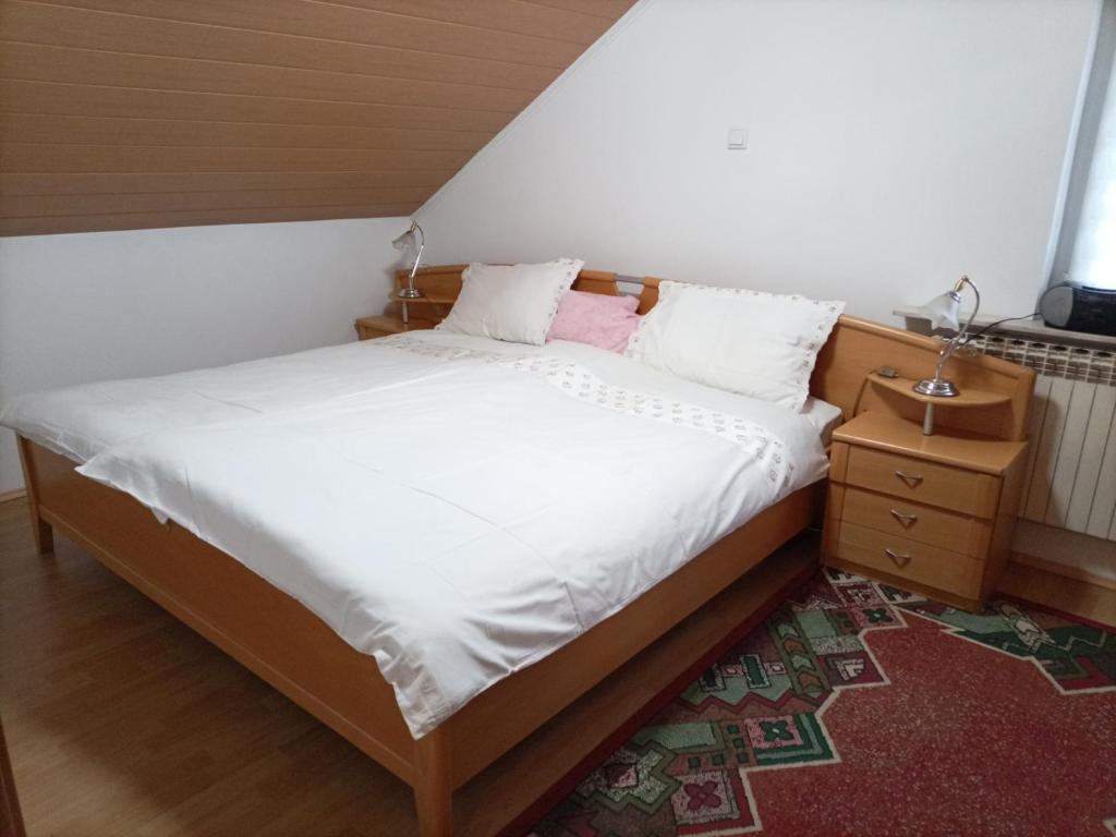 a bedroom with a bed and a nightstand with a white bed at Zimmer mit Doppelbett in Zagreb