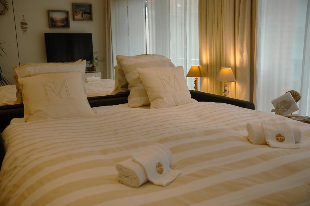 a large white bed with towels on top of it at The White coast studio in Nieuwpoort