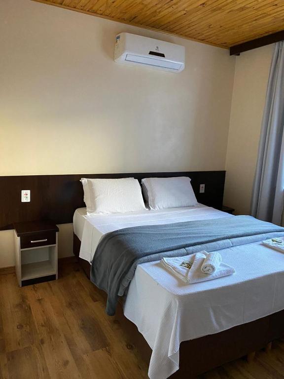 a bedroom with two beds with towels on them at Hotel Estrela in Cruz Machado