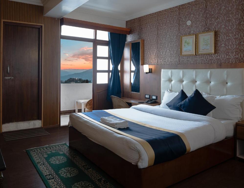 a hotel room with a large bed and a window at The Di-Lac Retreat in Gangtok