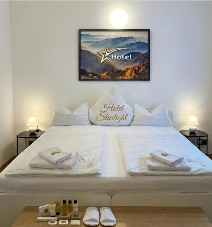 a large white bed with a hotel sign on it at Hotel Starlight in Frankfurt