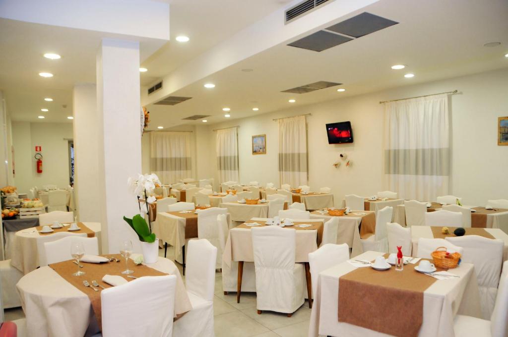 a banquet hall with white tables and white chairs at Hotel Venezia in Caorle