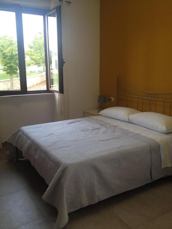 duże łóżko w sypialni z oknem w obiekcie B&B La Torre w mieście Rosello