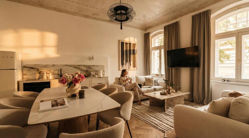 a living room with a woman sitting on a couch at La Belle Epoque in Warsaw