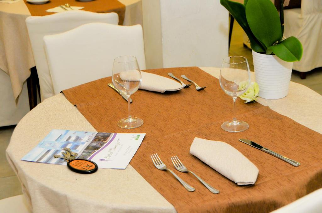 a table with wine glasses and napkins on it at Hotel Venezia in Caorle