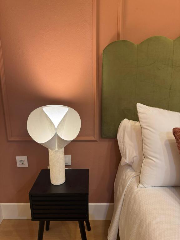 a lamp on a night stand next to a bed at Casa Lombarda in Mérida