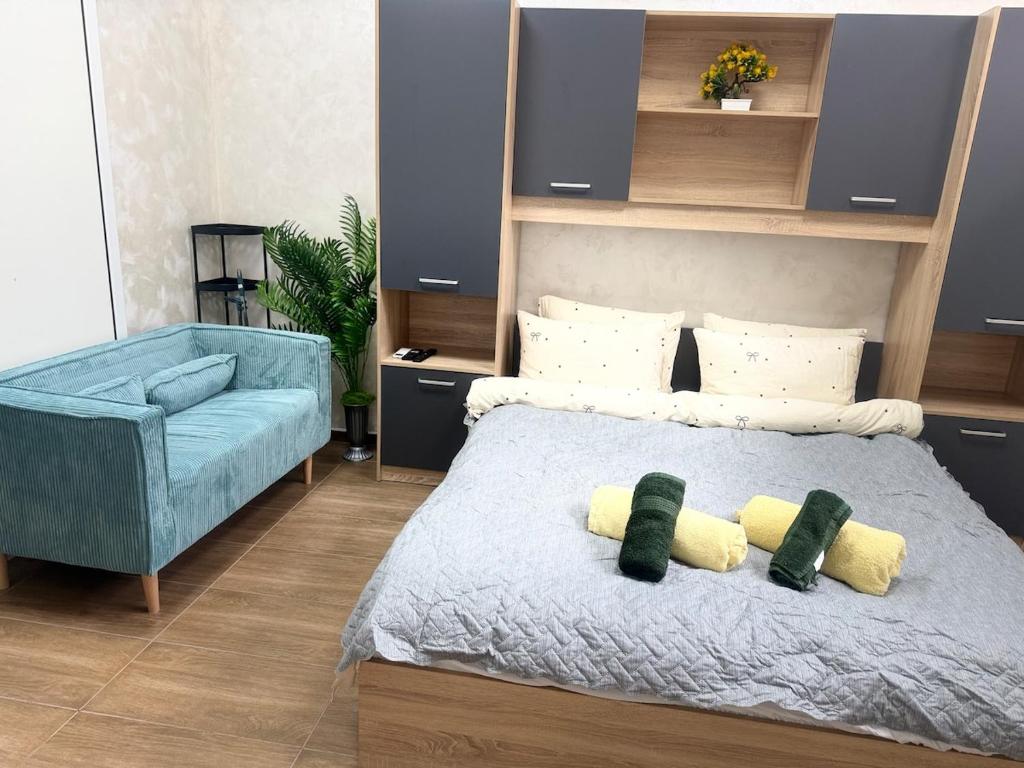 a bedroom with a bed and a blue couch at Cozy Corner 41 in Ruse