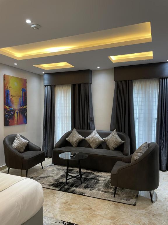 ein Wohnzimmer mit einer Couch und zwei Sesseln in der Unterkunft Ringruby Hotel, Oladipo Bateye in Lagos