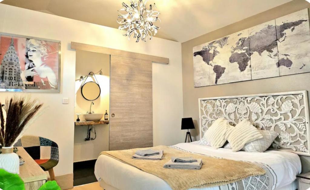 a bedroom with a large white bed and a chandelier at Chambre Belvédère in Porto-Vecchio