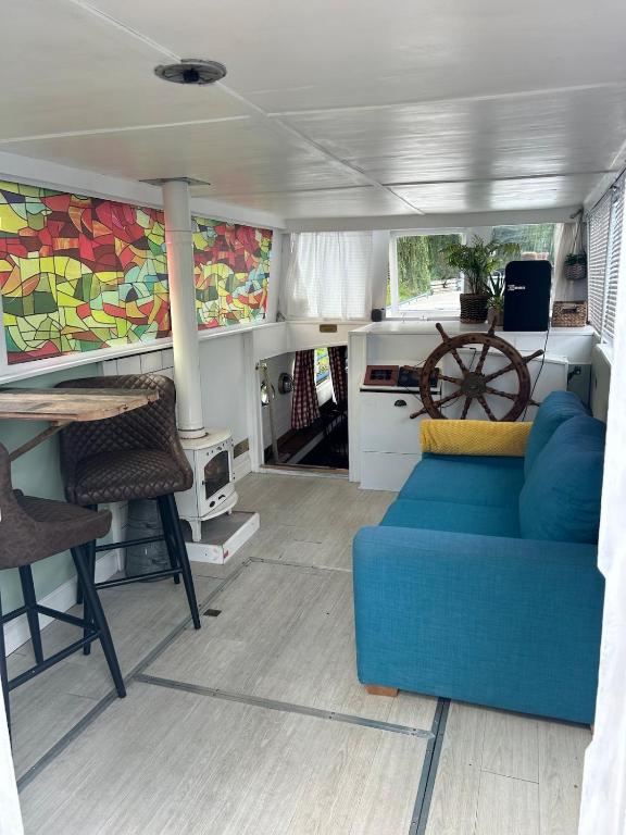 a living room with a blue couch and a table at Barge in central Cambridge in Cambridge