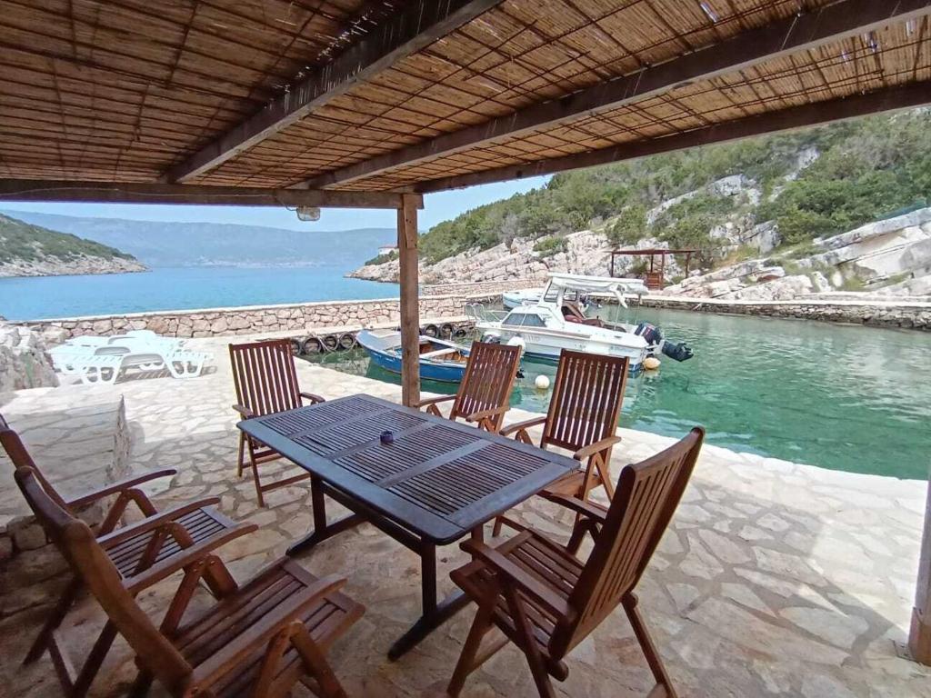 a table and chairs on a patio with a boat at Robinson Luminara in Vrbanj
