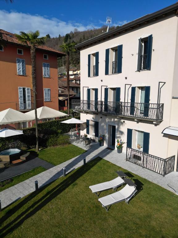 an external view of a building with two lawn chairs and umbrellas at Gio Leo Guest House in Lesa