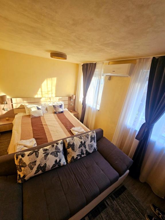 a bedroom with a bed and a couch in a room at Studio Iris in Baile Felix