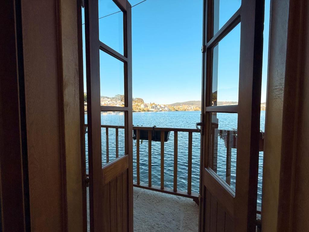 an open door with a view of the water at Casa da Escola in Combarro