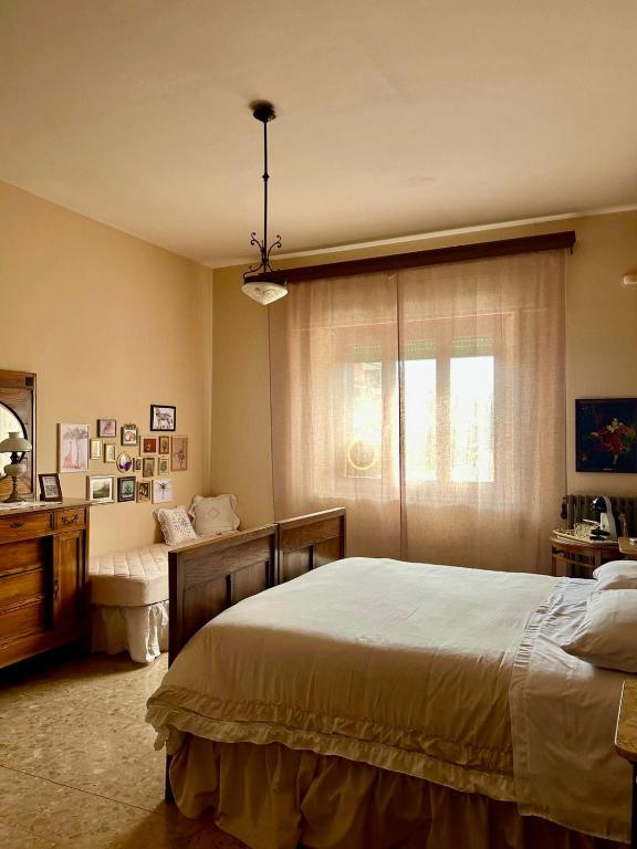 a bedroom with a bed and a dresser and a window at Villa Ada in Monsummano Terme