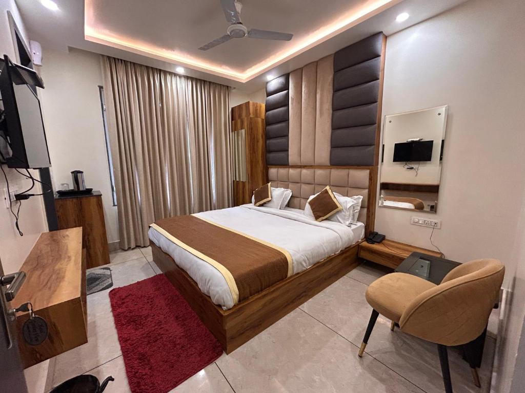 a bedroom with a bed and a tv and a chair at Garden view by Midtown in Katra