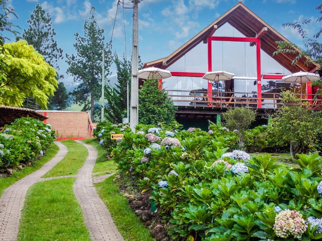 Un puente sobre un jardín con un camino y flores. en Pousada Monjolos de Minas a 9 km de Gonçalves, en Gonçalves