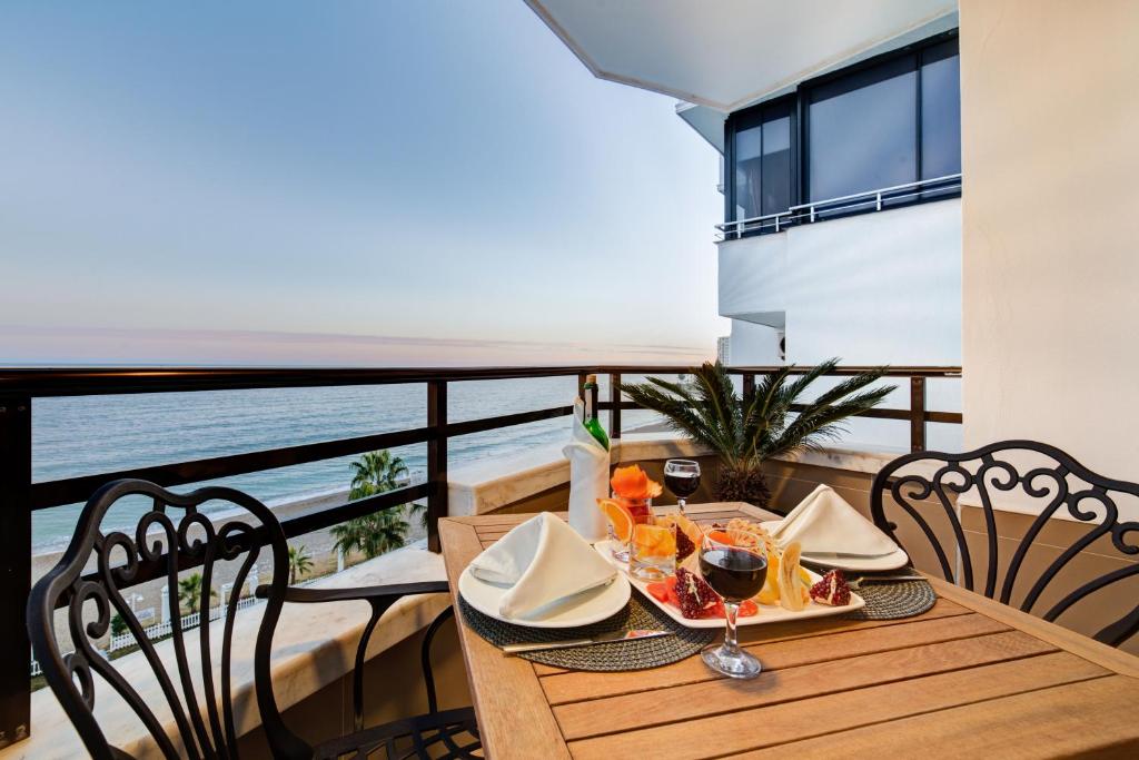 a table with a plate of food on a balcony at Sahil Martı Hotel in Mezitli