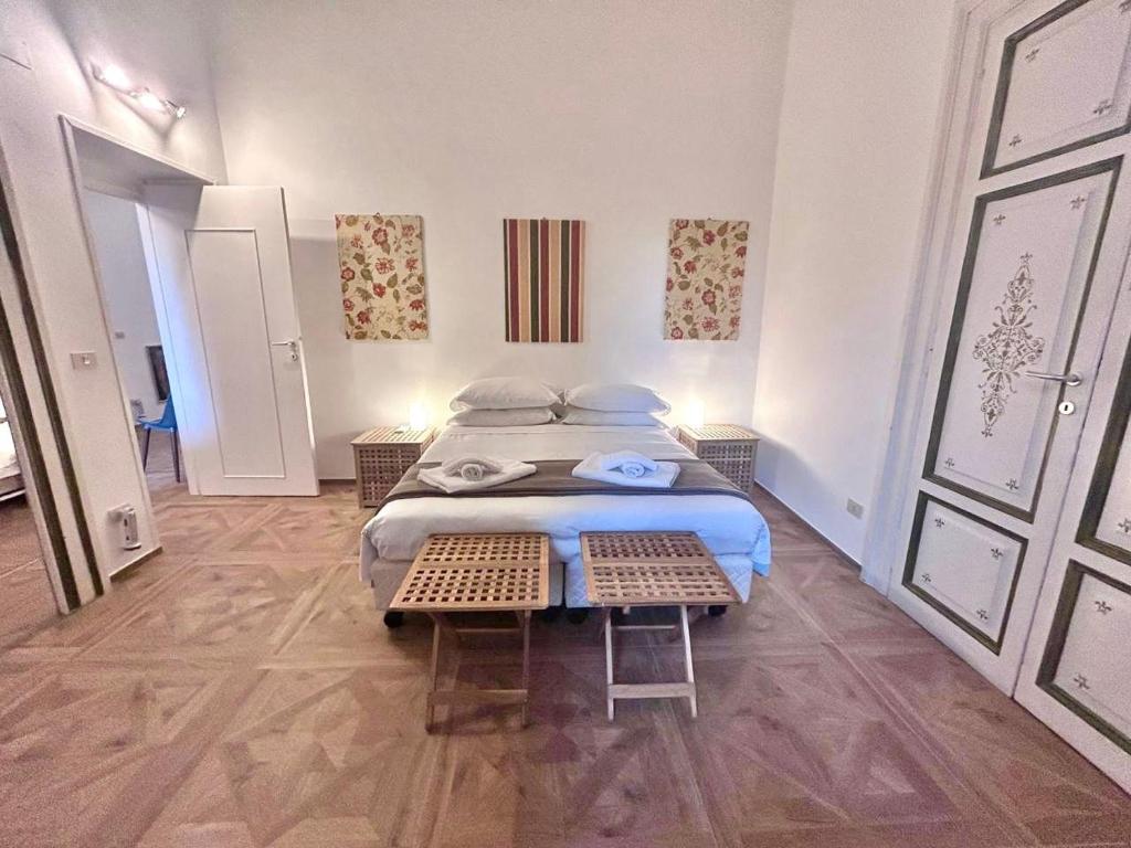 a bedroom with a bed and two chairs in it at Vicolo Doria Apartment in Rome