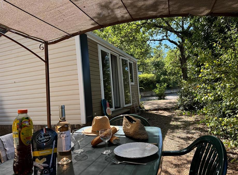 an outdoor table with wine glasses on a patio at Camping Le Soleil du Verdon in Esparron-de-Verdon