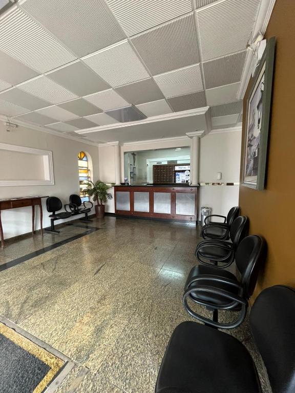 a waiting room with black chairs and a table at Hotel Muller in Mariana