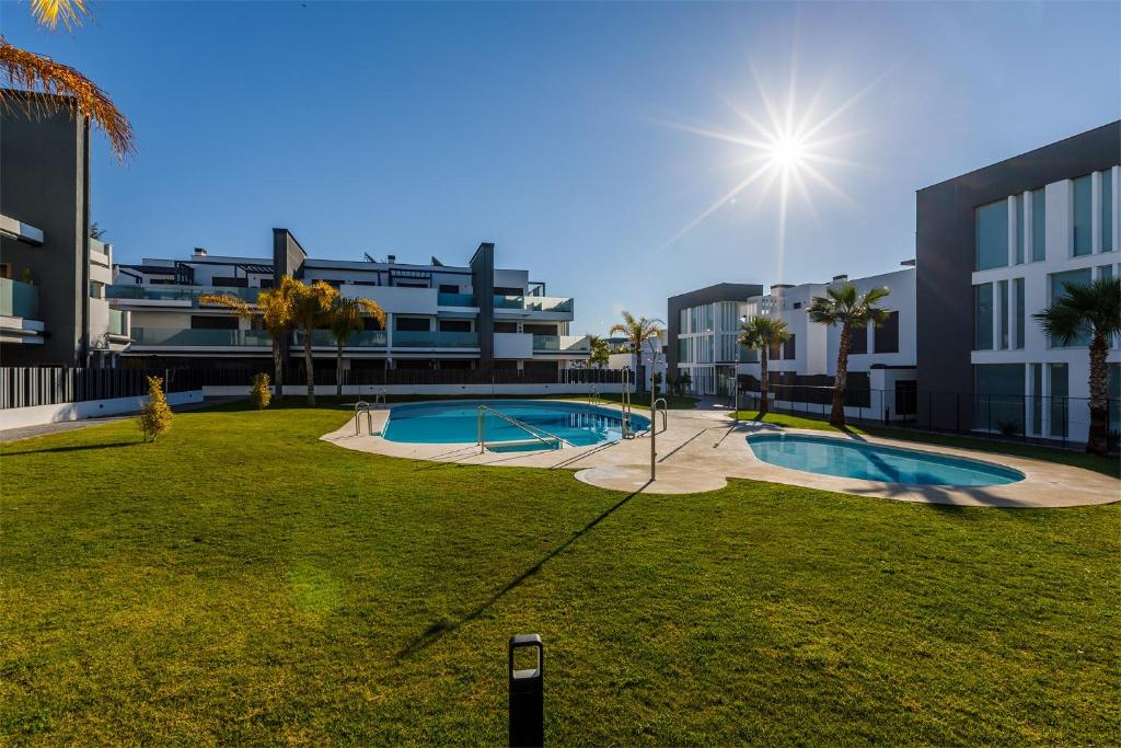 a large yard with a swimming pool in front of a building at A&N Sun Terrace Penthouse Caleta Marina in Caleta De Velez