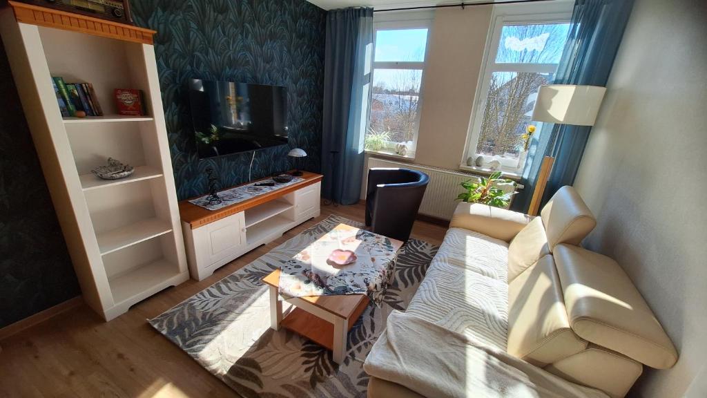 a living room with a couch and a tv at Ferienwohnung Heike "Zum Spatzennest" in Mühlhausen
