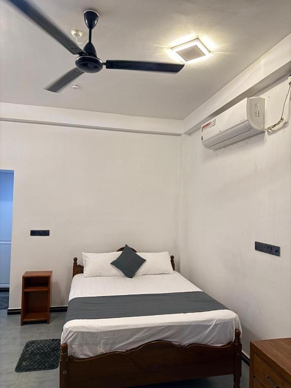 a bedroom with a bed with a ceiling fan at Diving Nest in Trincomalee