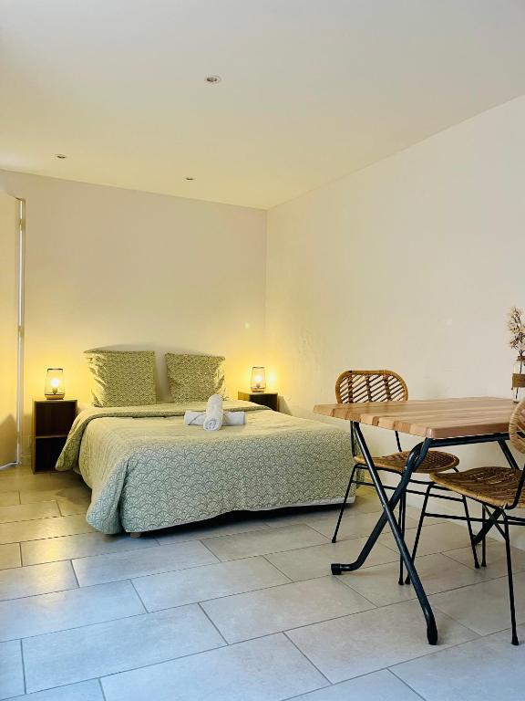ein Schlafzimmer mit einem Bett und einem Holztisch in der Unterkunft Studio El Canigou in Prades