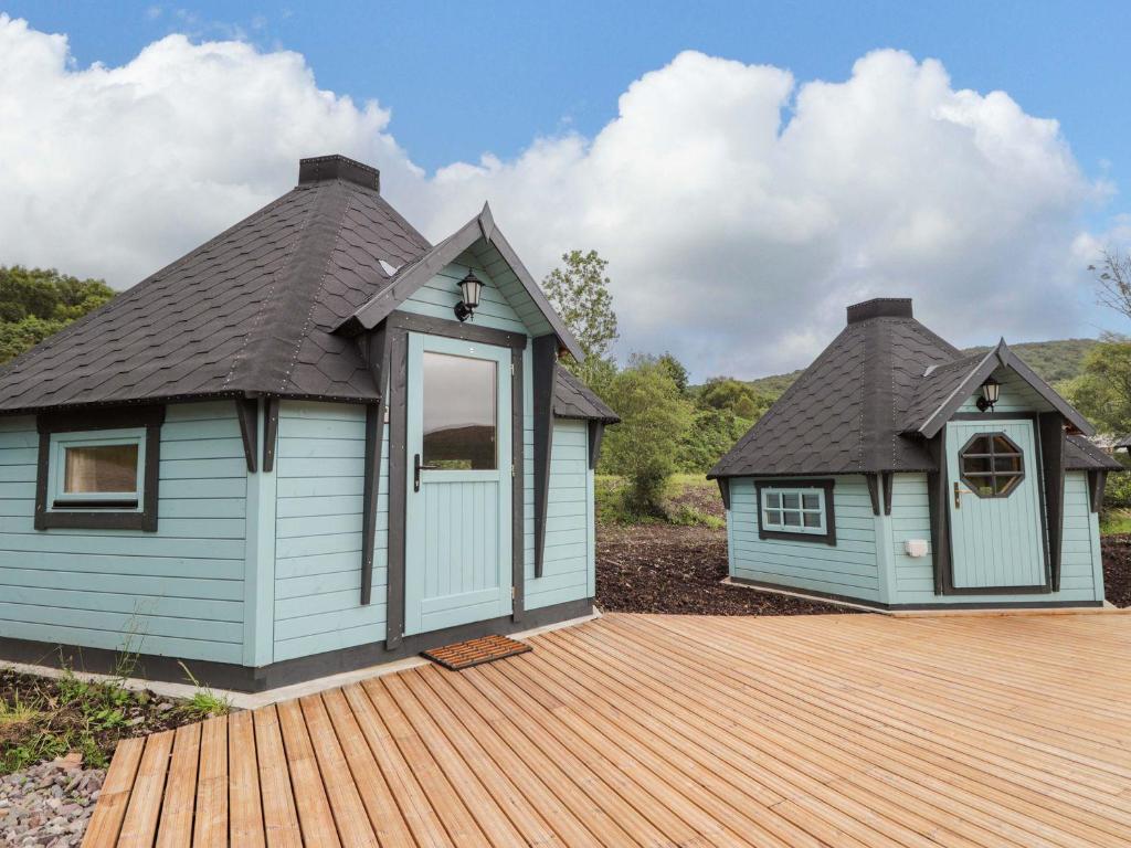 a small house with a roof on a wooden deck at Little Luxe Lodges 1 in Kyle of Lochalsh