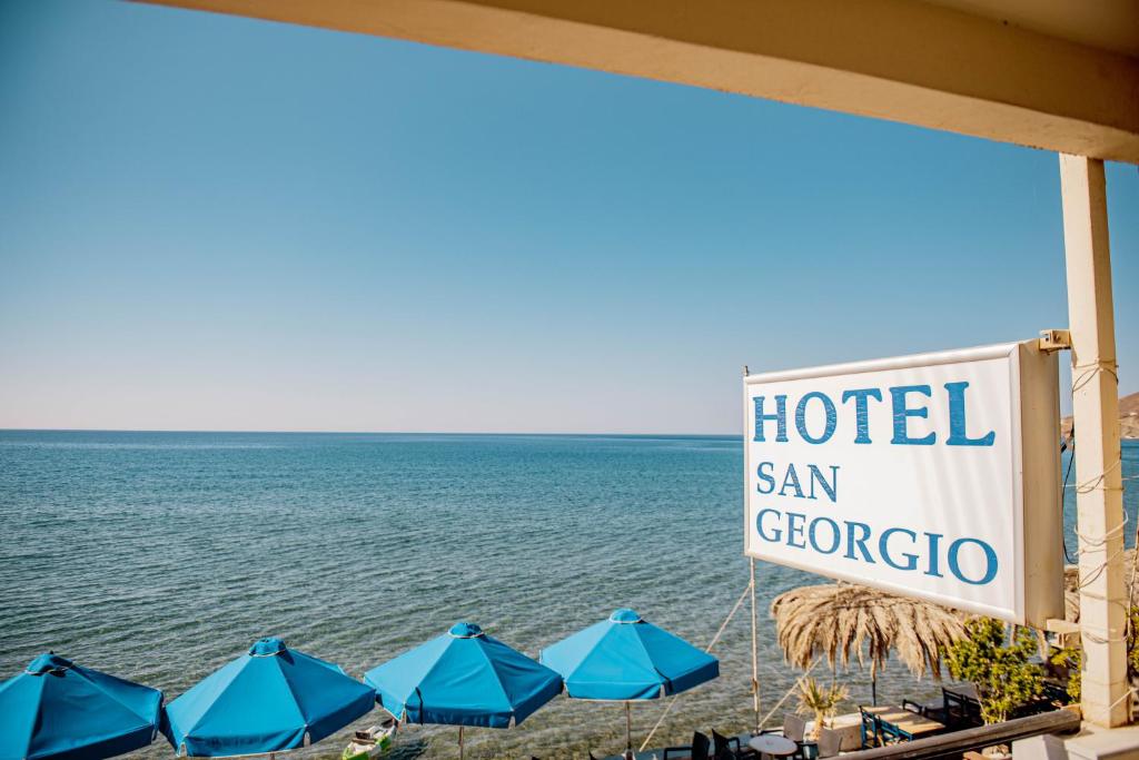 a sign for a hotel san gregorico next to the ocean at San Georgio Hotel in Tsoutsouros