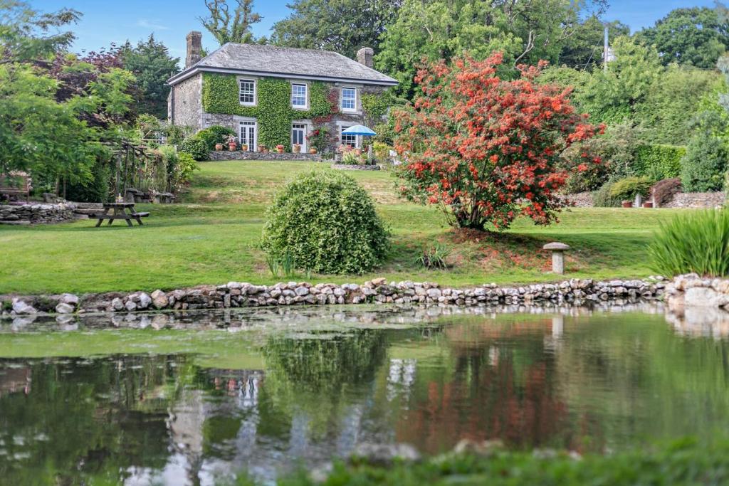 an old house with a pond in front of it at 3 Bed in Uphill oc-n27747 in Linkinhorne