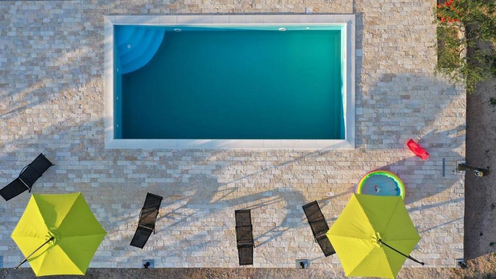 an overhead view of umbrellas and a swimming pool at Rooms Agro B&B Linda in Pirovac
