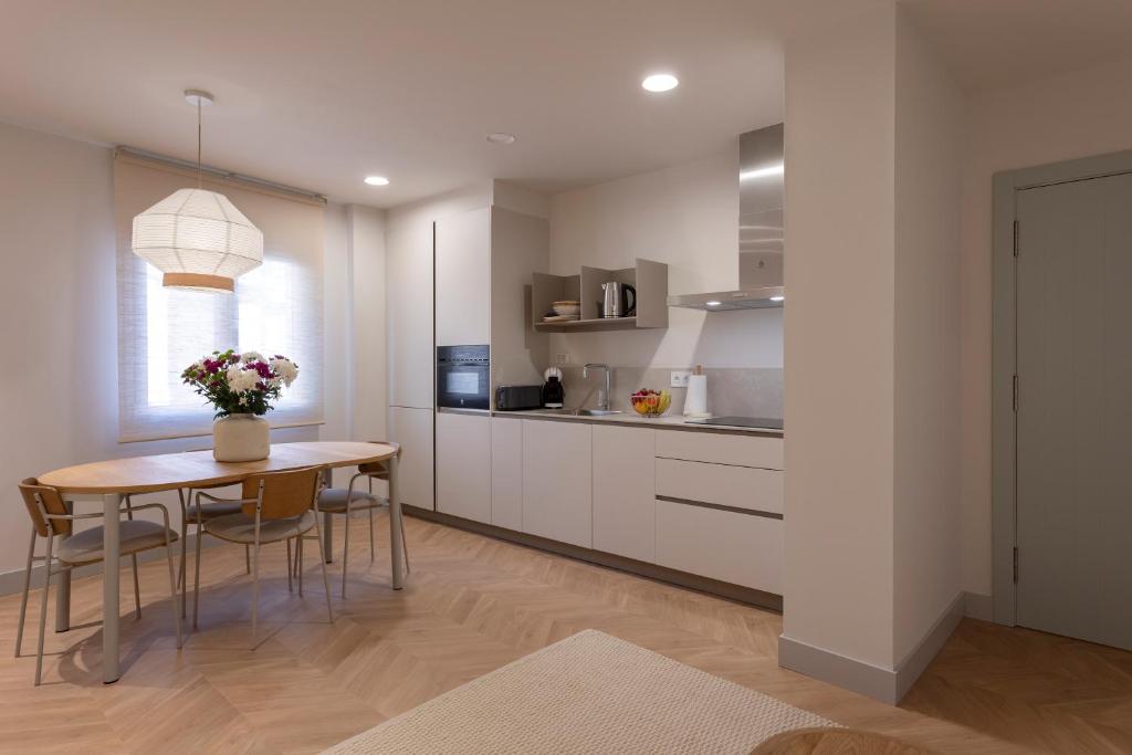 a kitchen with a table and chairs and a table and a counter at Apartamentos Boutique Casco Histórico in Las Lagunas