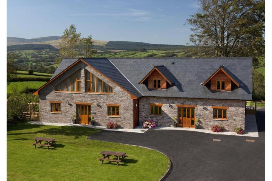 a stone house with two picnic tables in front of it at 9 Bed in Brecon oc-cvelo in Cray
