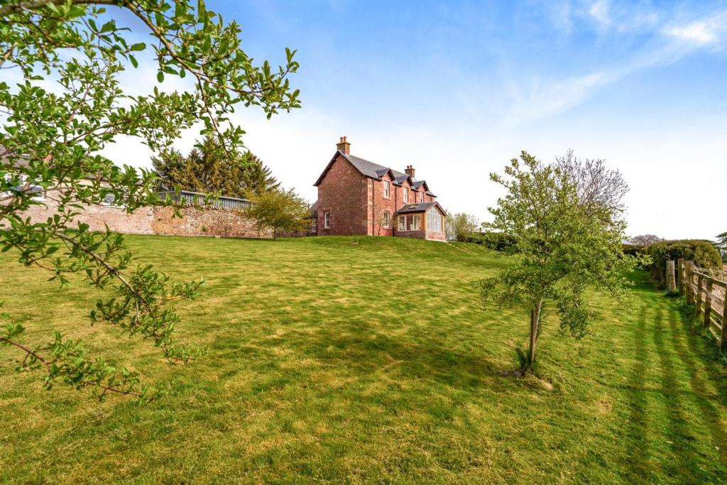 a house on a hill with a tree in the grass at 4 Bed in Alyth oc-e31853 in Bridgend of Lintrathen