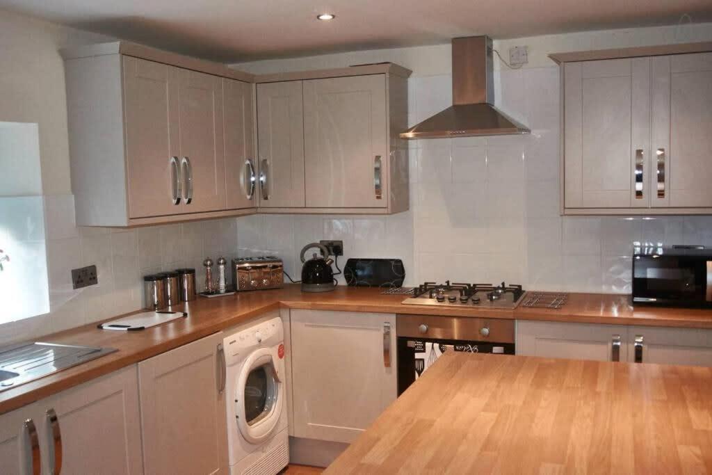 a kitchen with white cabinets and a washing machine at 103 Whalley Road Ramsbottom in Ramsbottom