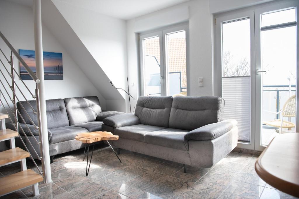 a living room with a couch and a table at Haus-Eriel-OG-rechts in Brösum