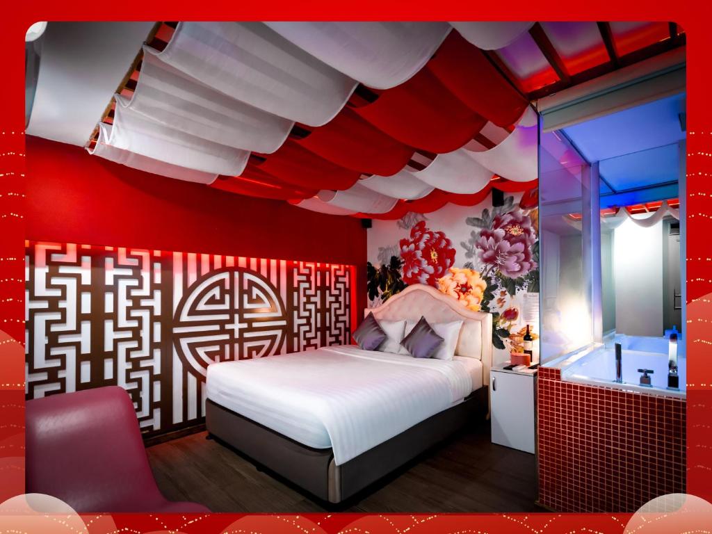 a red bedroom with a bed and a mirror at Cupid Hotel in Ho Chi Minh City