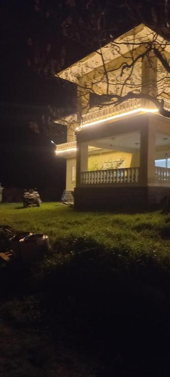 a house with lights on the front of it at night at Gökçen Çiftliği Pansiyon in Eceabat
