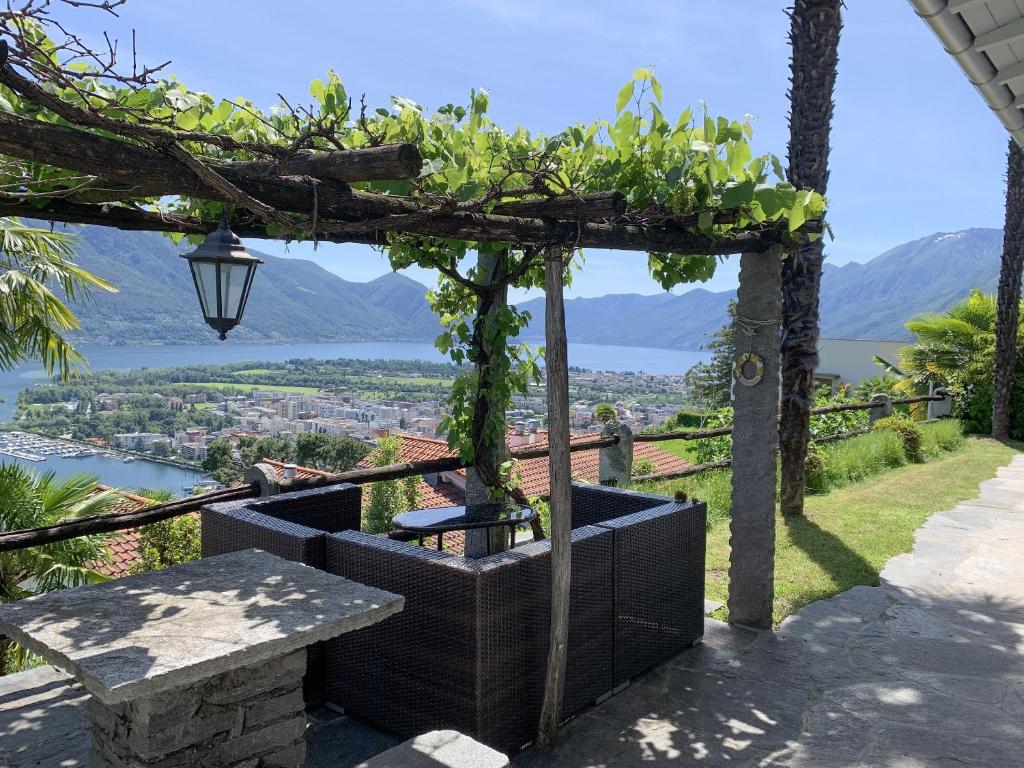 a pergola with a table and a view at Casa Rondinella by fewotessin in Orselina